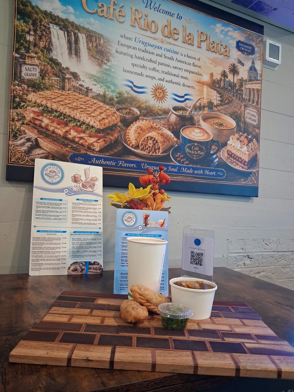 Signature menu items pictured at Café Rio de la Plata include the Carne con Queso and Pride of Rio de la Plata empanadas, Puchero stew and yerba mate drinks.
